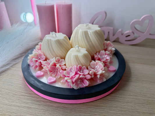 Handgegossene Deko-Schale mit drei cremefarbenen Kerzen, rosa Blüten und Herzen – romantisches Arrangement auf rundem Tablett, liebevoll dekoriert.