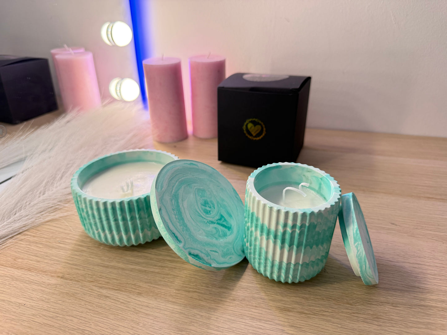 Edle Kerzen im marmorierten Design in Grau und Weiß, dekoriert mit Rosen, Geschenkbox und warmem Licht