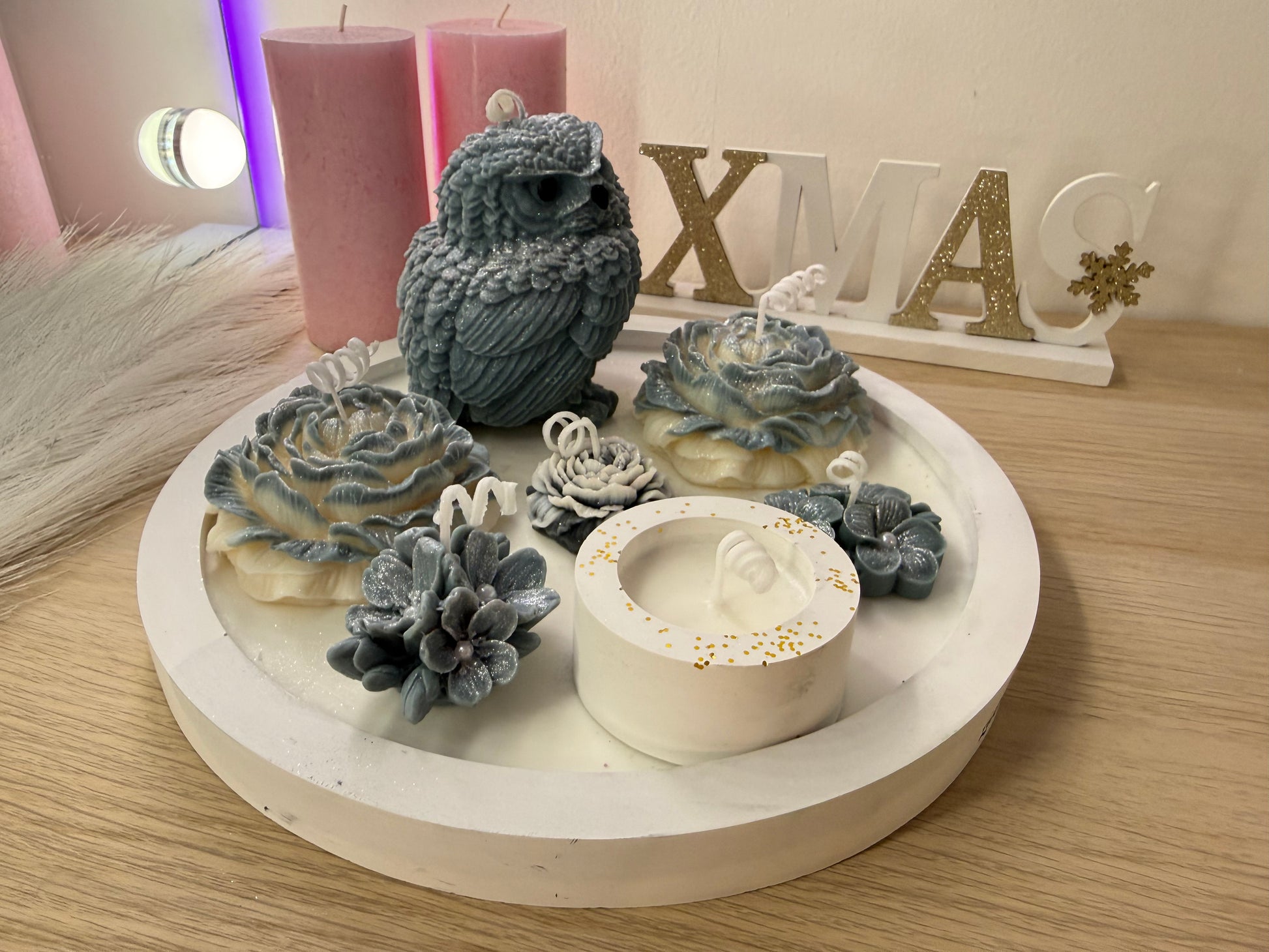 Grau-weißes Winterarrangement mit handgegossener Eule und Pfingstrosen in einer dekorativen Schale.