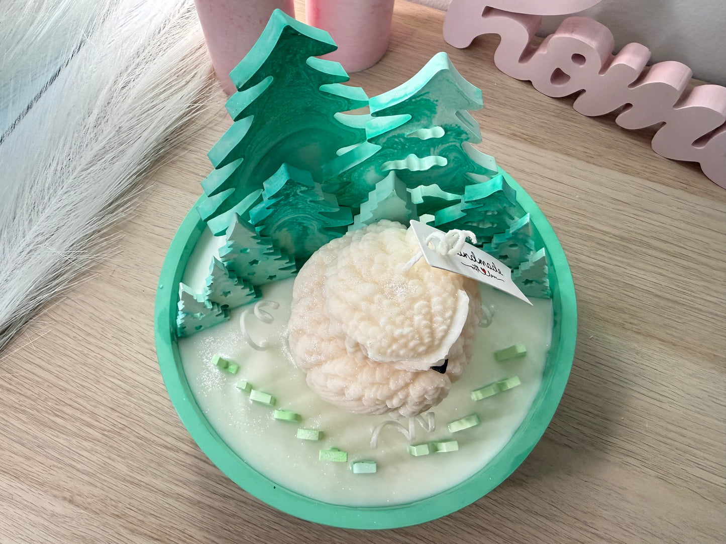 Mintgrüne 3D-Tannenbäume aus Gips in einer handgemachten Winter-Schale, fotografiert mit warmem Licht von hinten.