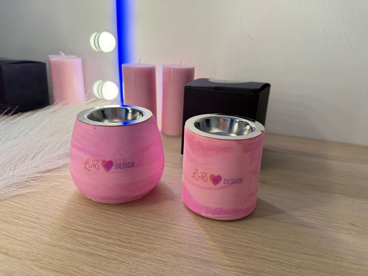 Stilvolle Kerzenhalter in zartem Rosa mit edlem Design, dekoriert mit Rosen und Geschenkbox im warmen Licht