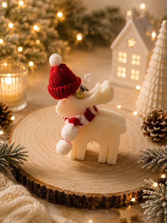 Handgemachte Rentier-Kerze in Cremeweiß mit roter Strickmütze, Schal und goldenem Glöckchen als weihnachtliche Dekoration von LuRi Design