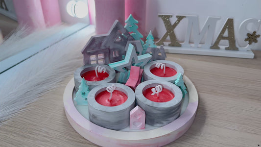 Handgegossene Adventsschale mit vier roten Kerzen, Häuschen und Tannenbäumen in Pastellfarben – moderne Weihnachtsdekoration handmade.